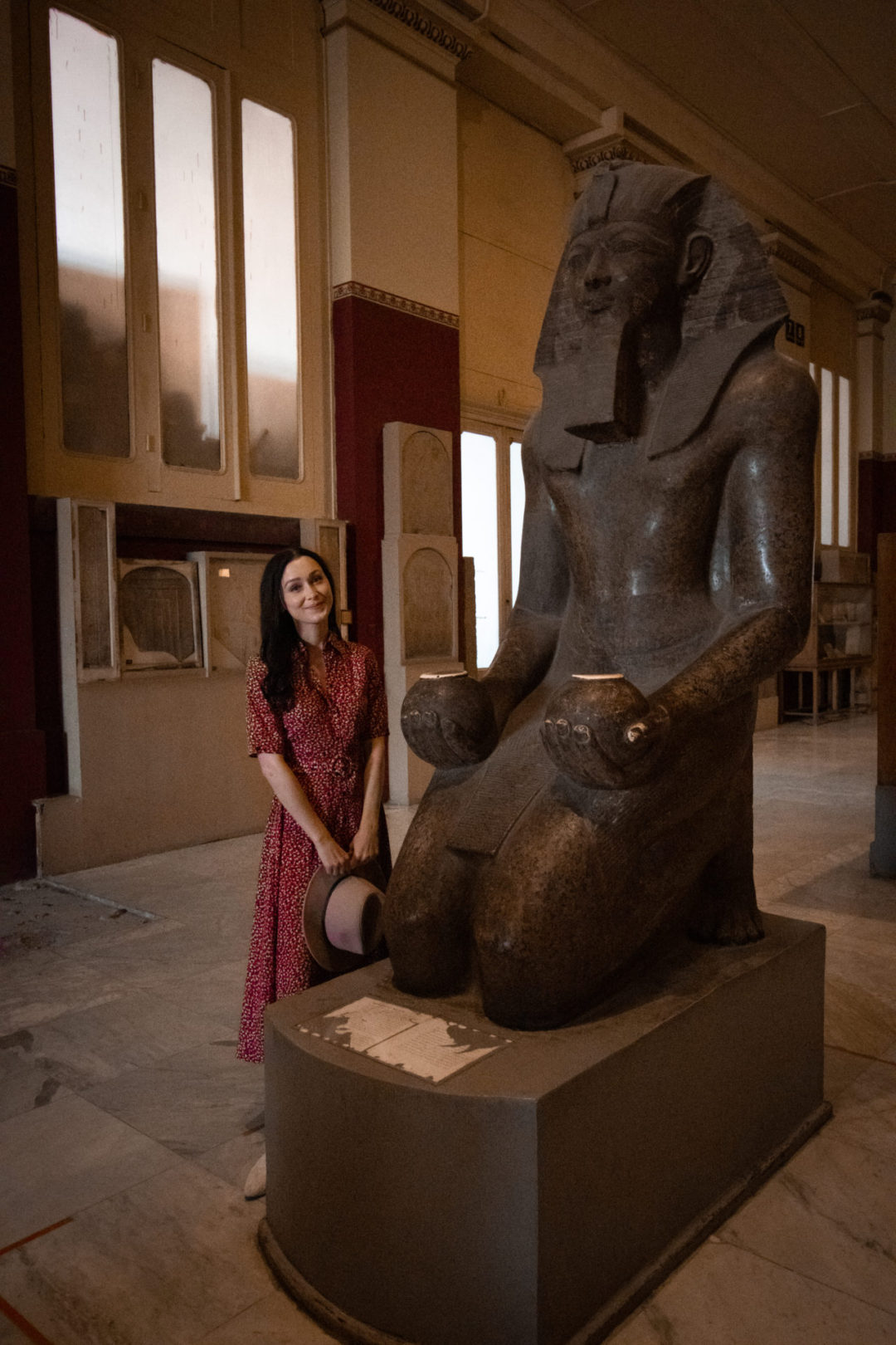 Travel Blogger Jordan Gassner smiling near a statue of Pharaoh Hatshepsut inside the Museum of Antiquities in Cairo