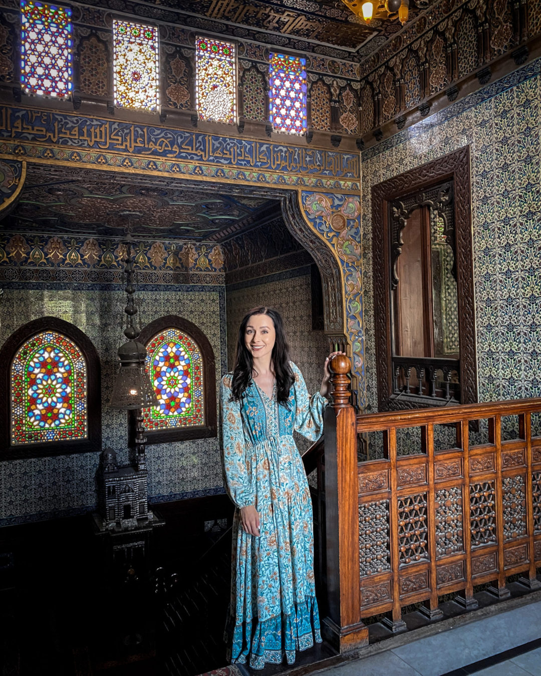 Travel Blogger Jordan Gassner standing at the top of a staircase inside the elegant and opulent Manial Palace Museum in Egypt