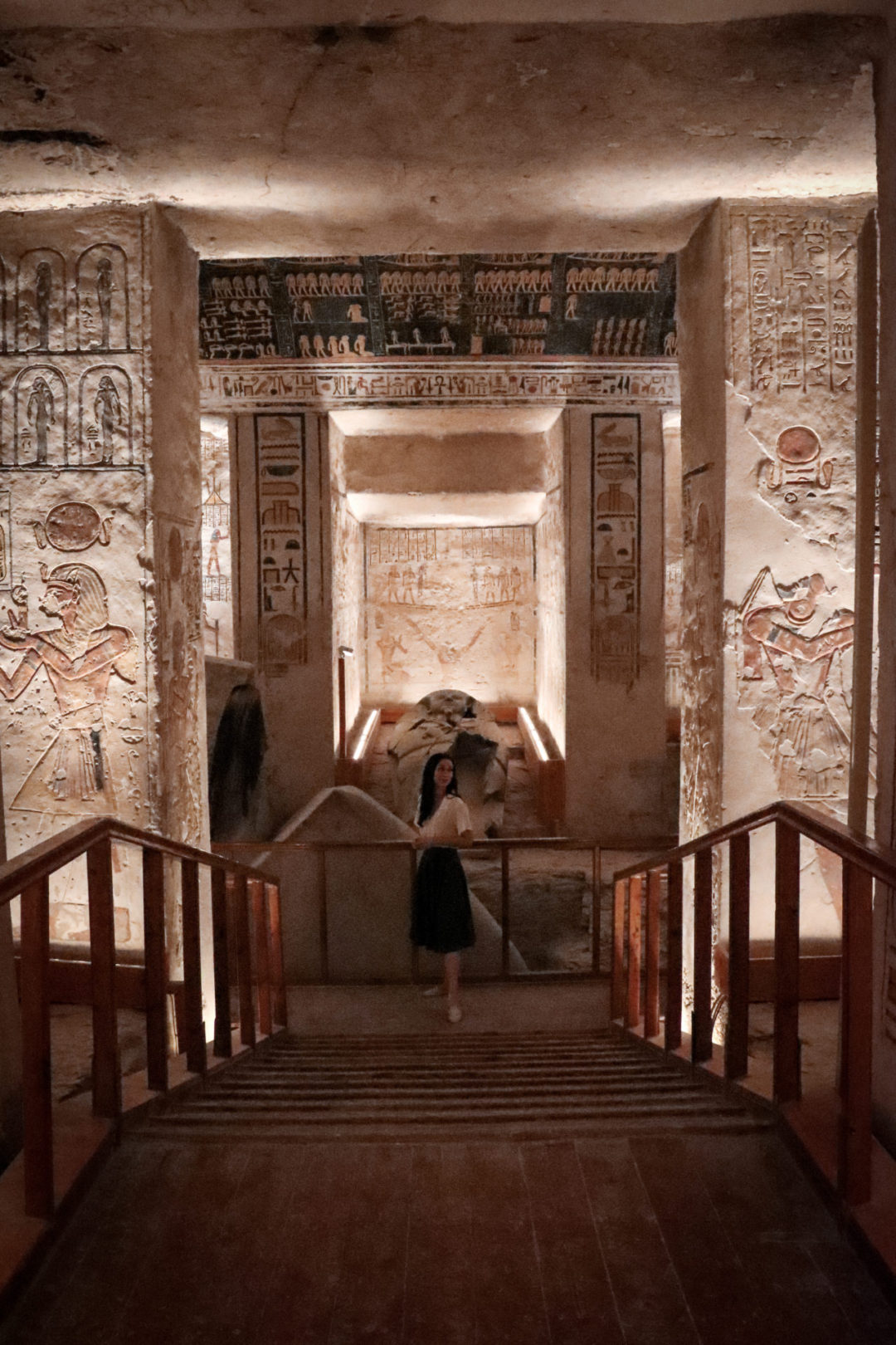 Travel Blogger Jordan Gassner standing and smiling in front of a broken sarcophagus inside a tomb in Egypt's Valley of the Kings