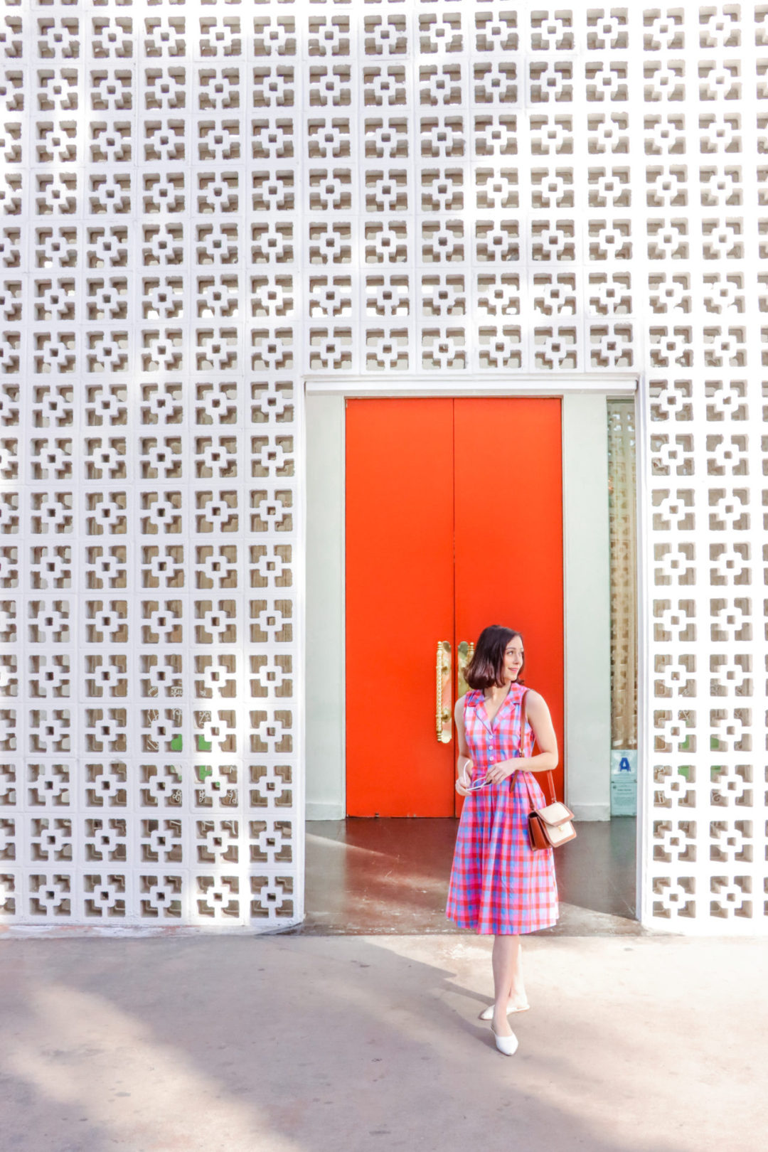 Travel Blogger Jordan Gassner standing outside the famous mid-century modern entrance to the Palm Springs Parker Hotel in Southern California