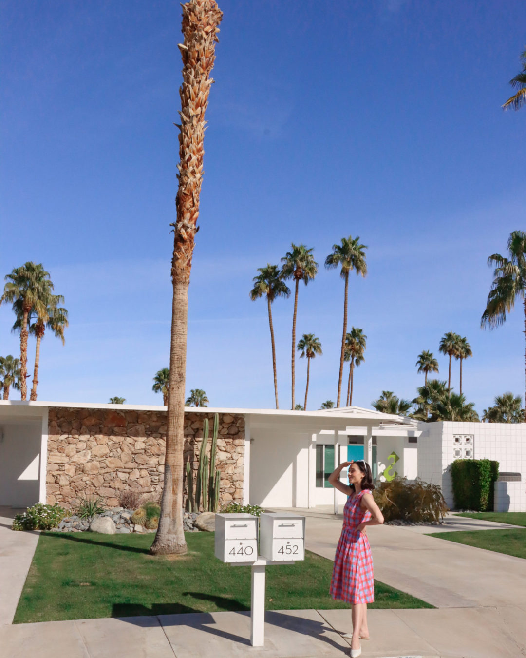 Travel Blogger Jordan Gassner shielding her eyes from the sun in front of Alice and Jack's Home from Don't Worry Darling