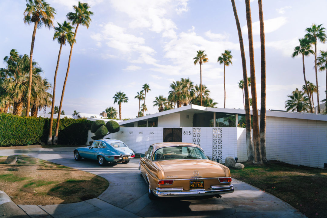 Two vintage cars in front of a mid-century modern home in Palm Springs, California, USA