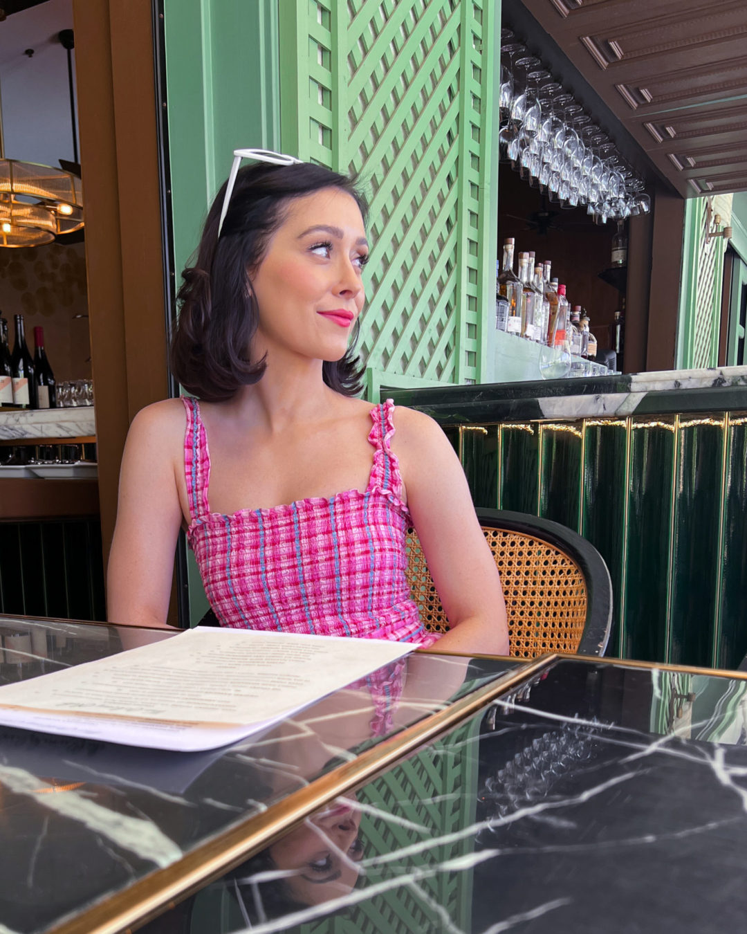 Travel Blogger Jordan Gassner wearing a vintage-inspired pink dress while dining at the Colony Palm Restaurant in Palm Springs, California
