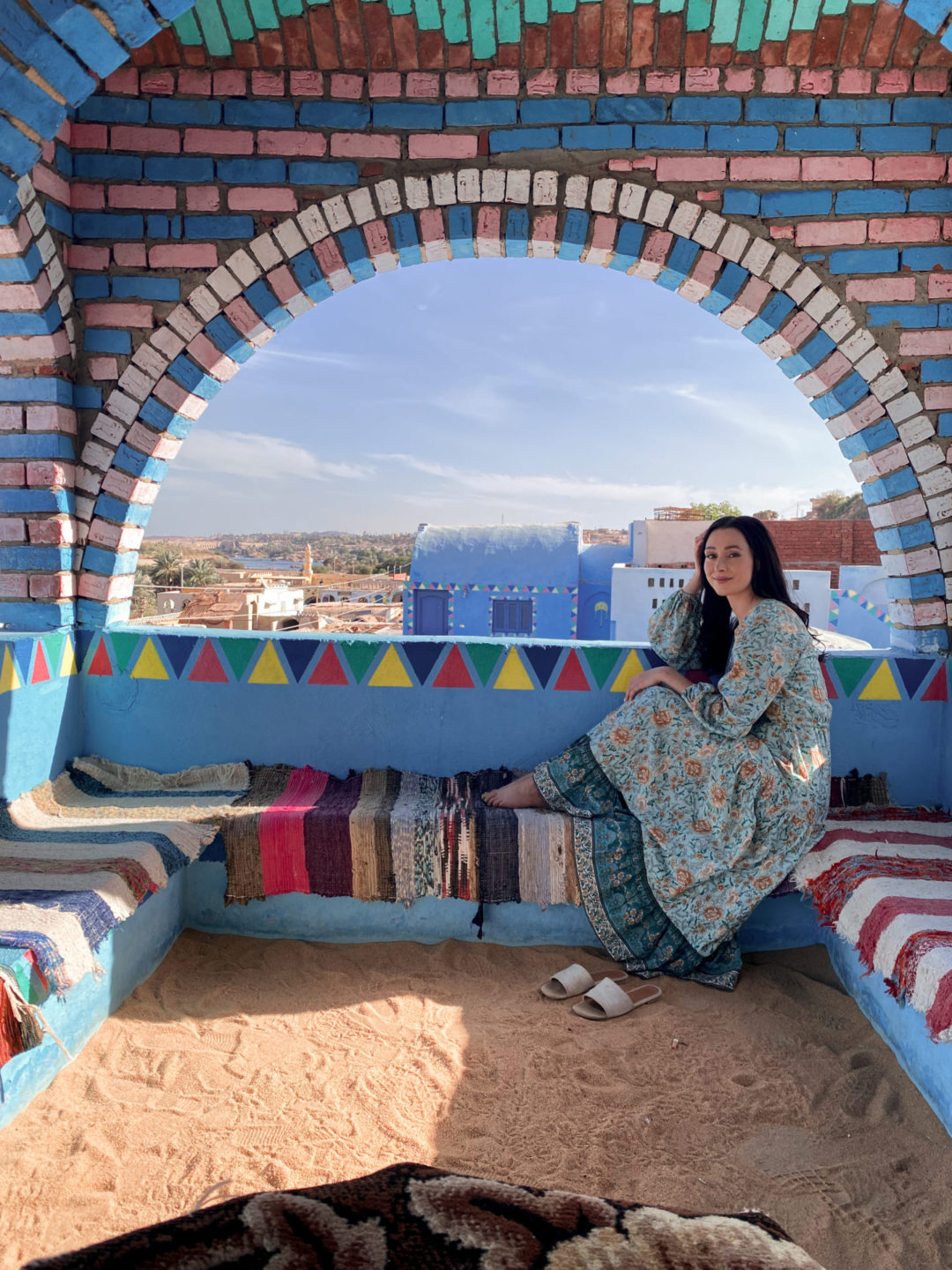 Travel Blogger Jordan Gassner sitting on top of a second floor viewpoint in Aswan's Nubian Village in Egypt