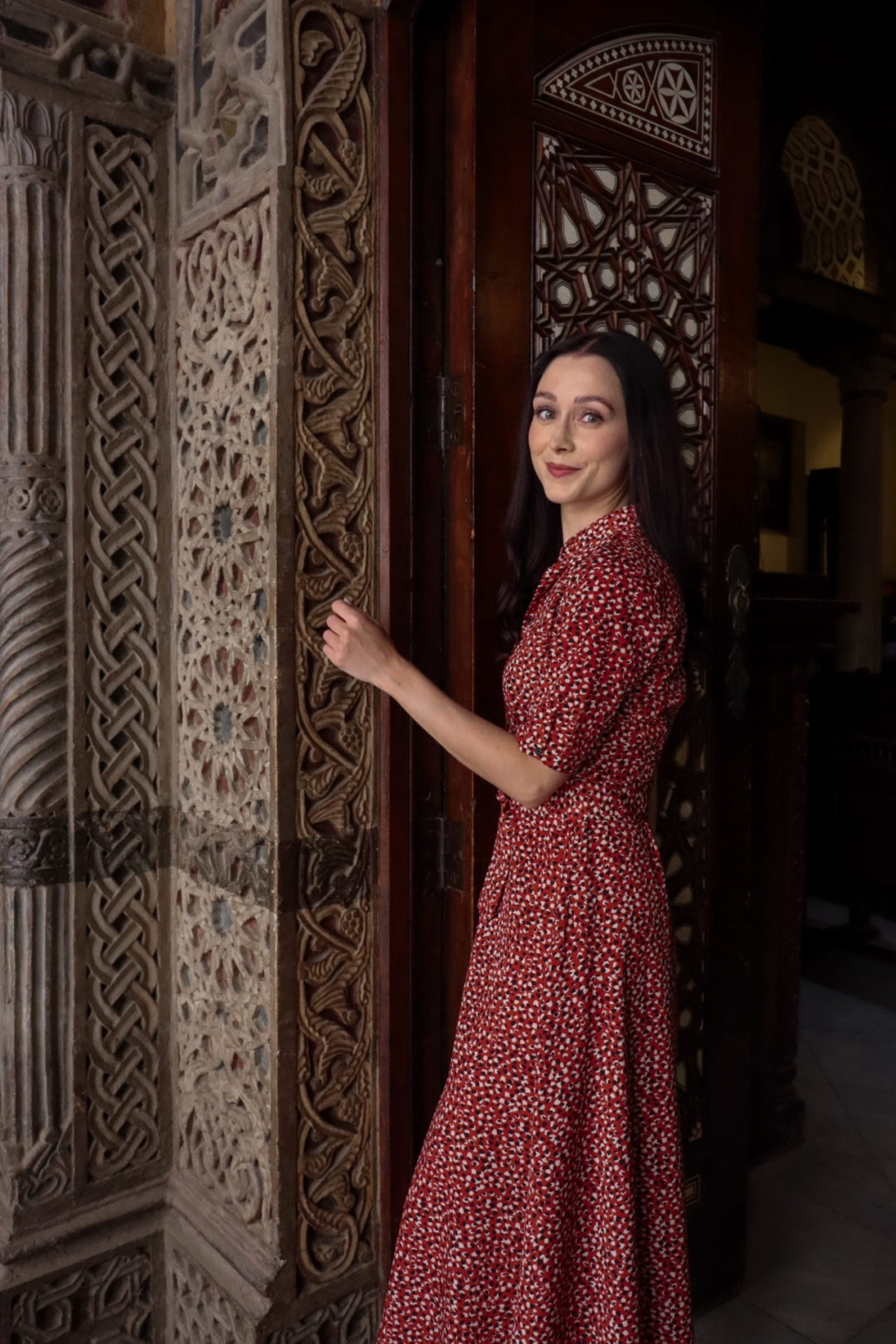 Travel Blogger Jordan Gassner smiling in a doorway leading inside Coptic Cairo's Hanging Church