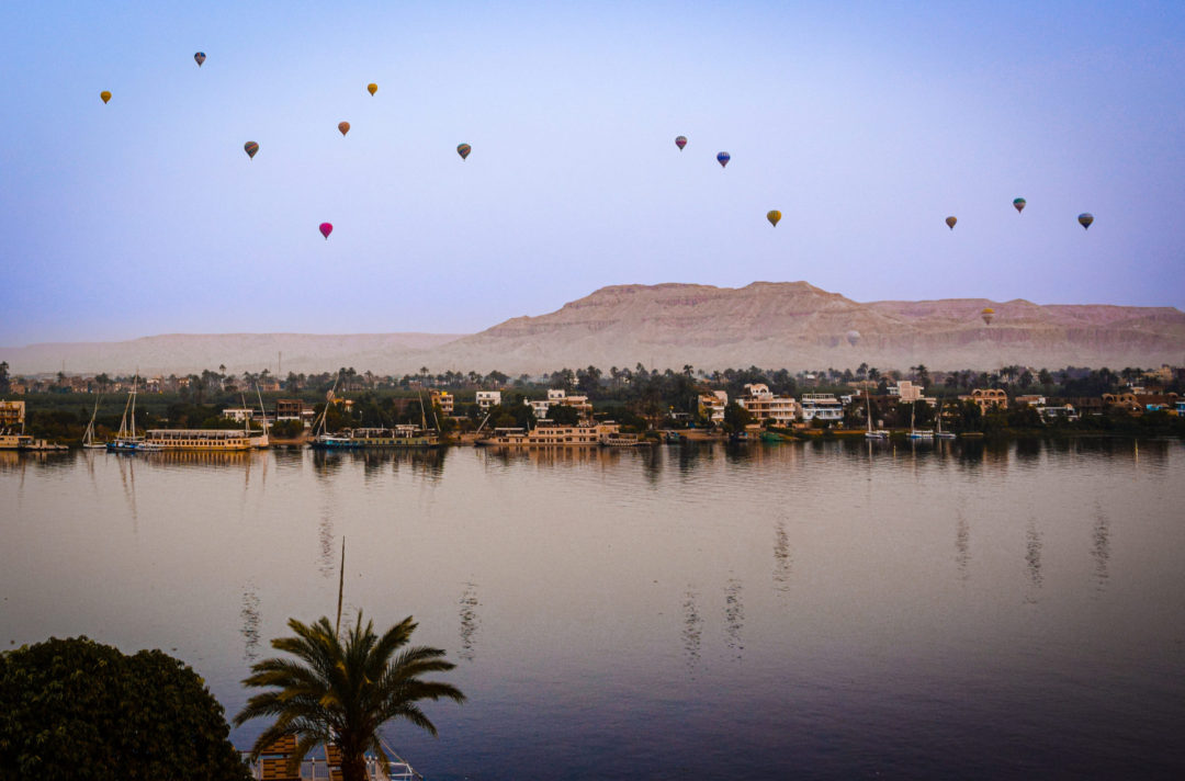A group of Hot Air Balloons soaring above Luxor from across the Nile River in Egypt