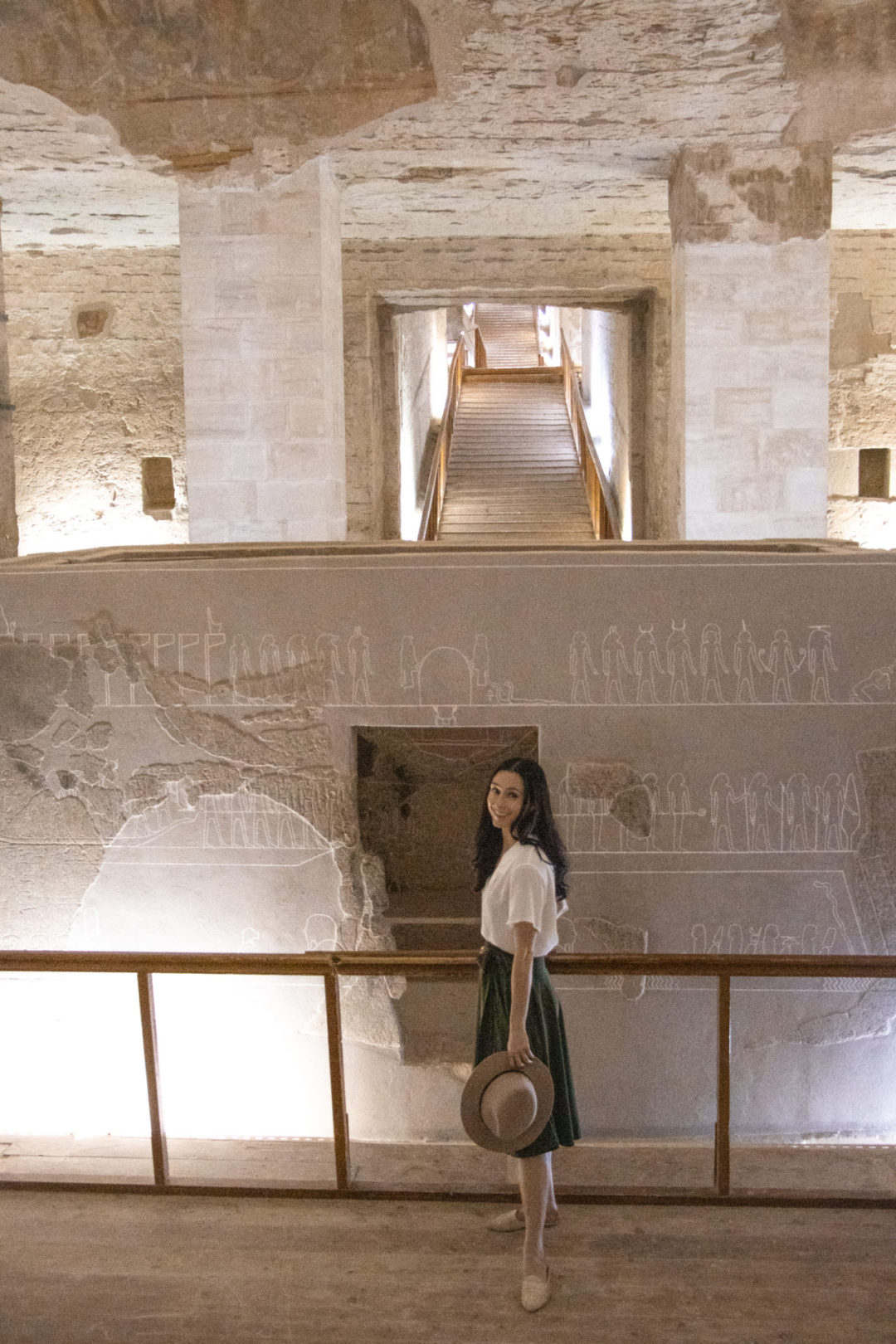 Travel Blogger Jordan Gassner smiling next to the large sarcophagus inside the Tomb of Merenptah in Luxor, Egypt