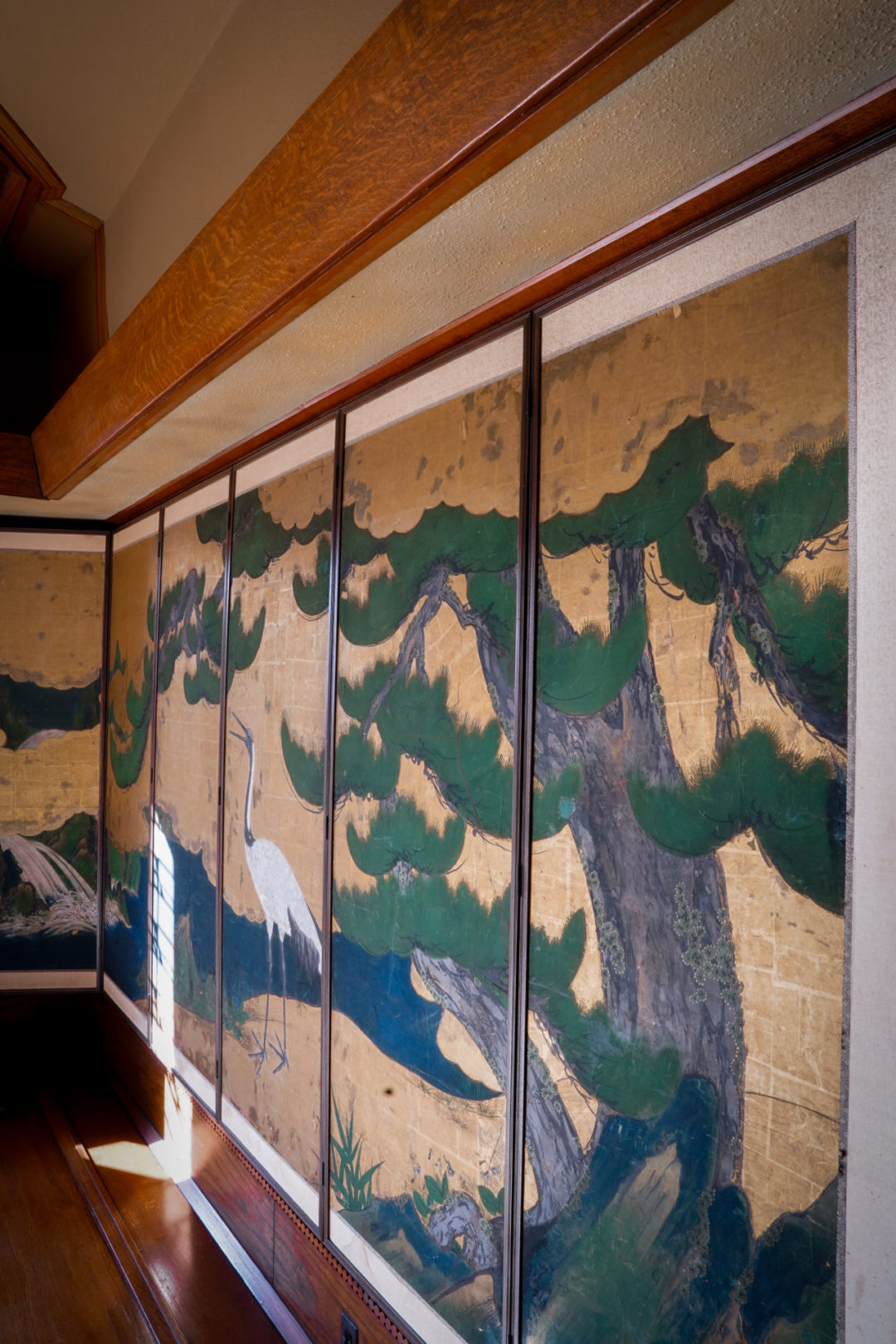 A piece of wall art showing a crane near a stream decorating the walls of Hollyhock House's living room