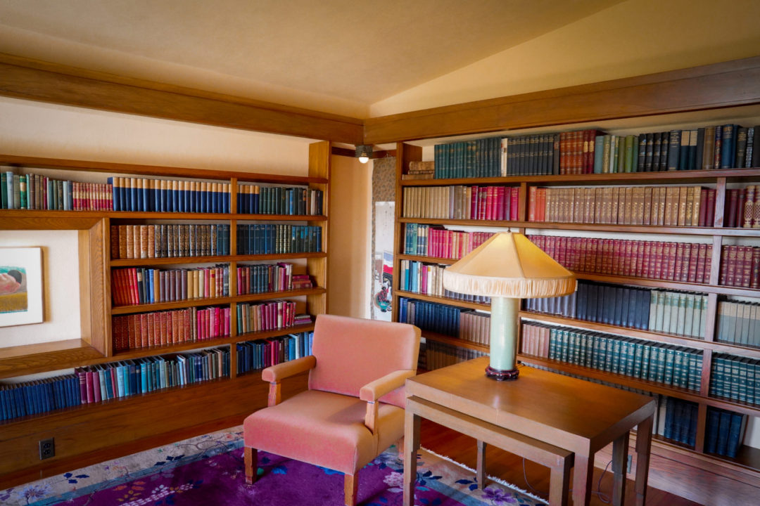 A pink velvet chair and vintage lamp inside the library of Hollyhock House in Los Angeles, California