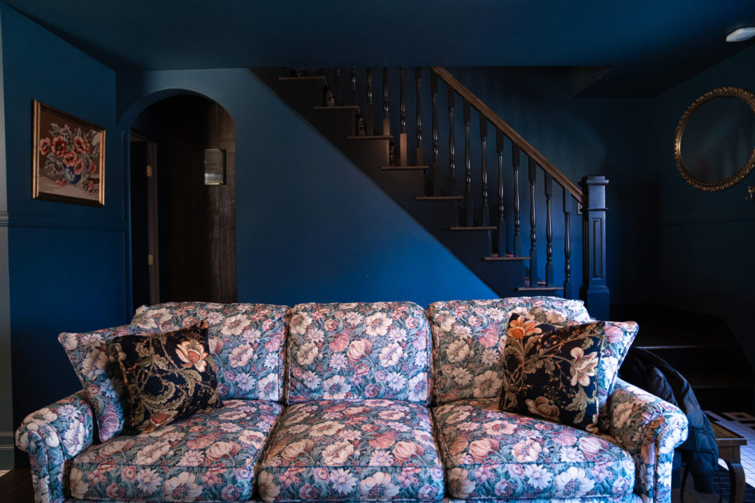 The blue living room and purple floral sofa inside Lucille's Manor at the Noble + Proper Hotel in Big Bear, California
