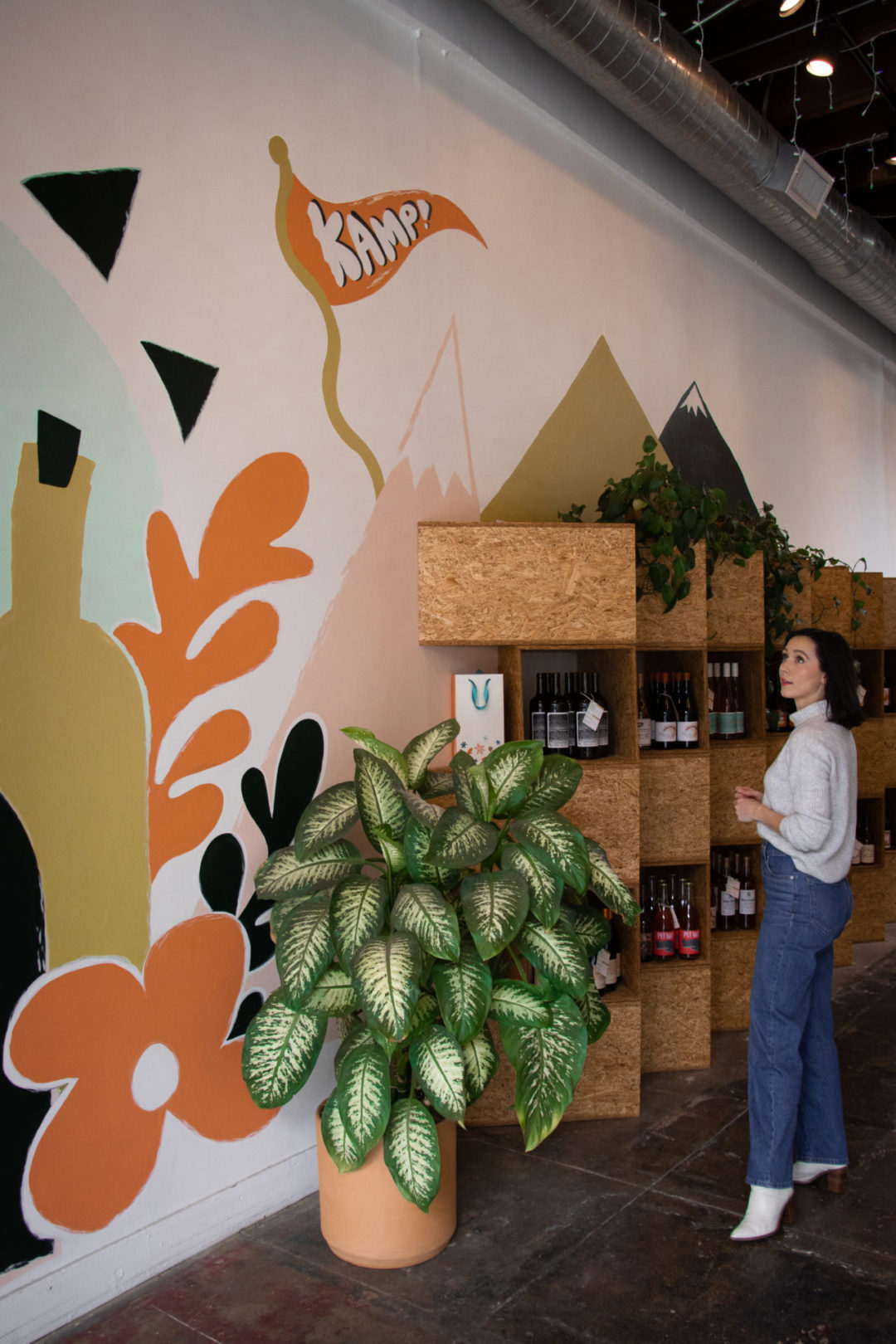 Travel Blogger Jordan Gassner looking at the KAMP wall art inside KAMP Wine Shop in Los Angeles' Silverlake neighborhood