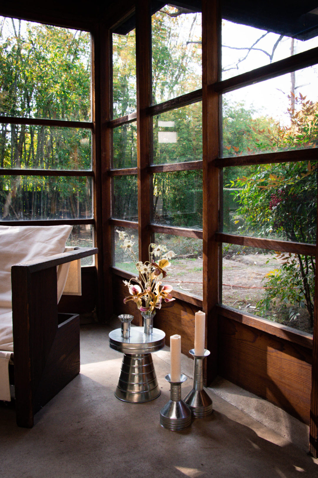 Home Tours in Los Angeles: A chair, vase of flowers and candles inside the historic Schindler House in West Hollywood, California, USA