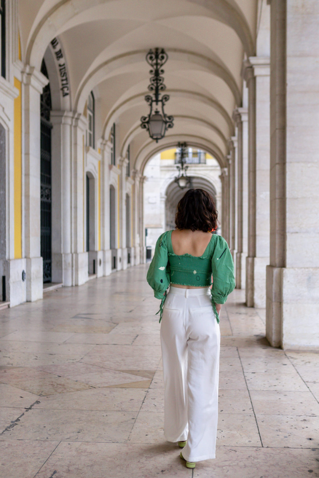 Travel Blogger Jordan Gassner walking under the archway of Praça do Comércio in the city center of Lisbon, Portugal