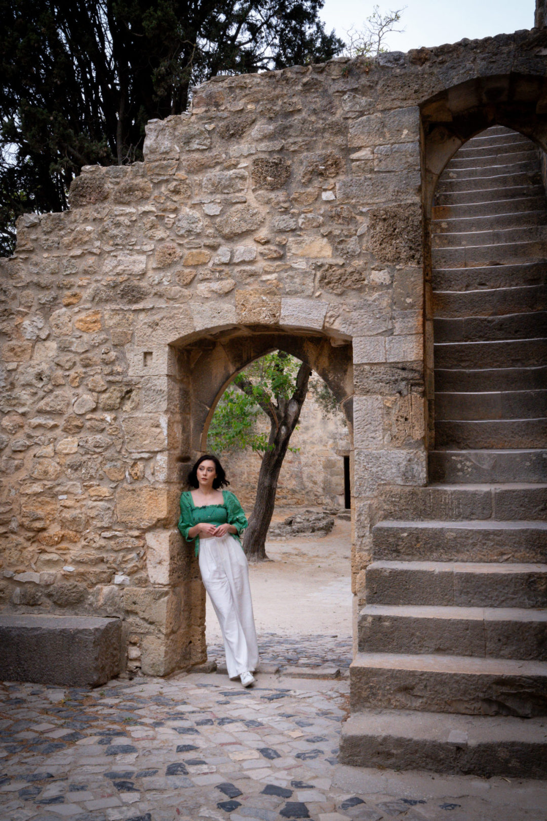 Lisbon Travel Guide: Travel Blogger Jordan Gassner leaning against a stone doorway inside Castelo de São Jorge