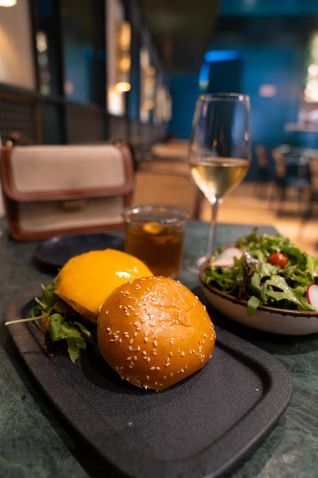 The Cascais Cheeseburger, a side salad and a white wine from The Green Affair, a vegan restaurant in the Chiado neighborhood of Lisbon