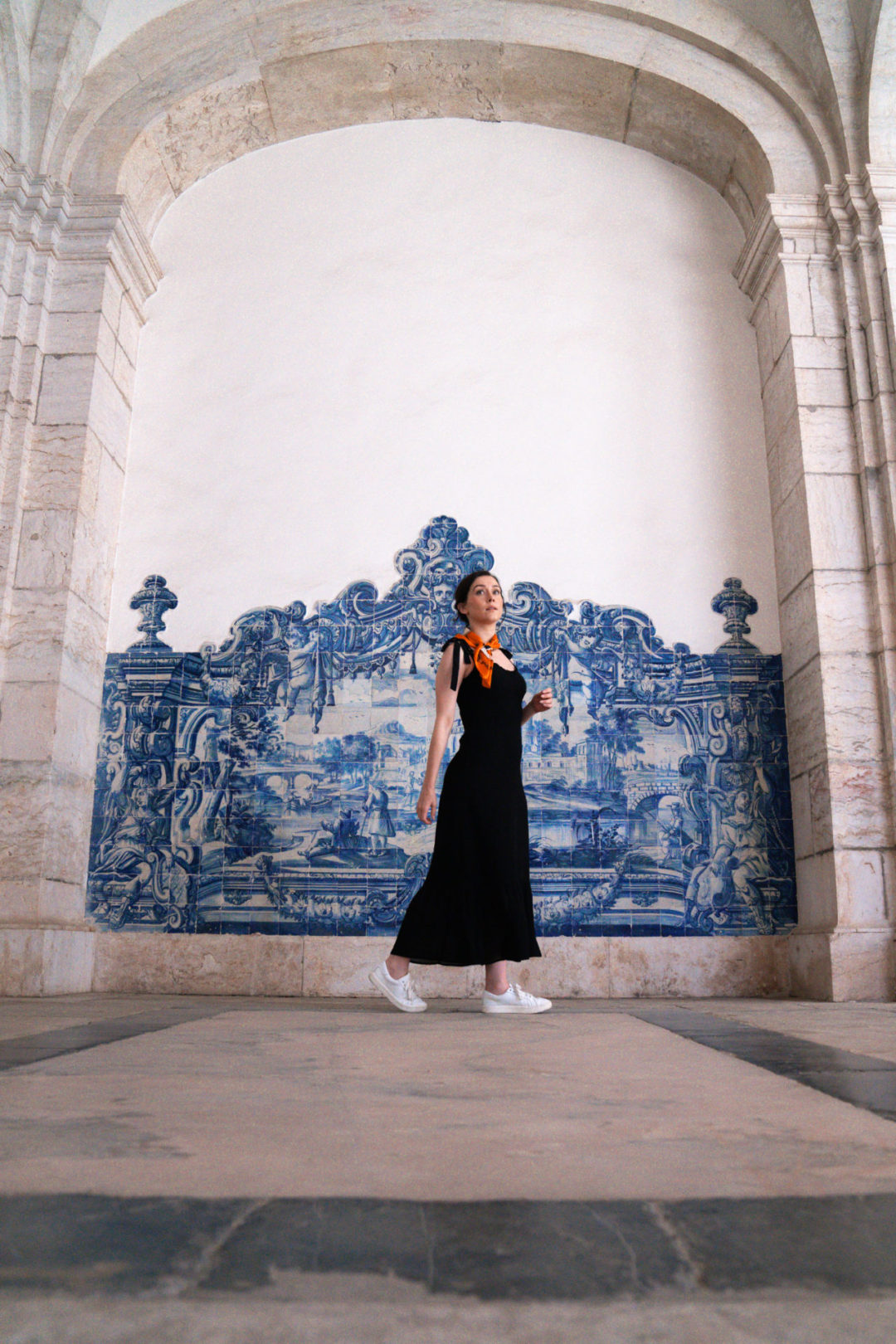 Jordan Gassner walking in front of a wall of azulejo tiles in Mosteiro São Vicente De Fora in Lisbon, Portugal