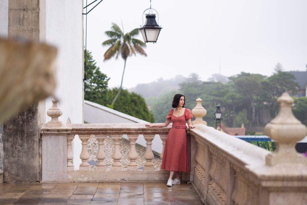 Travel Blogger Jordan Gassner peering over a balcony at Sintra National Palace in Portugal