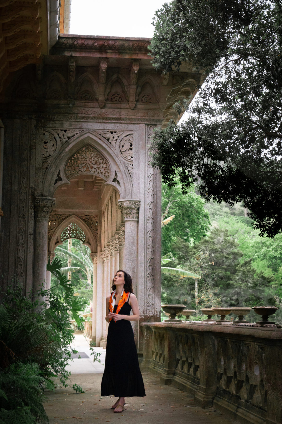 Travel Blogger Jordan Gassner admiring the architecture at Monserrate Palace in Sintra Portugal while wearing a black Reformation Nikita dress