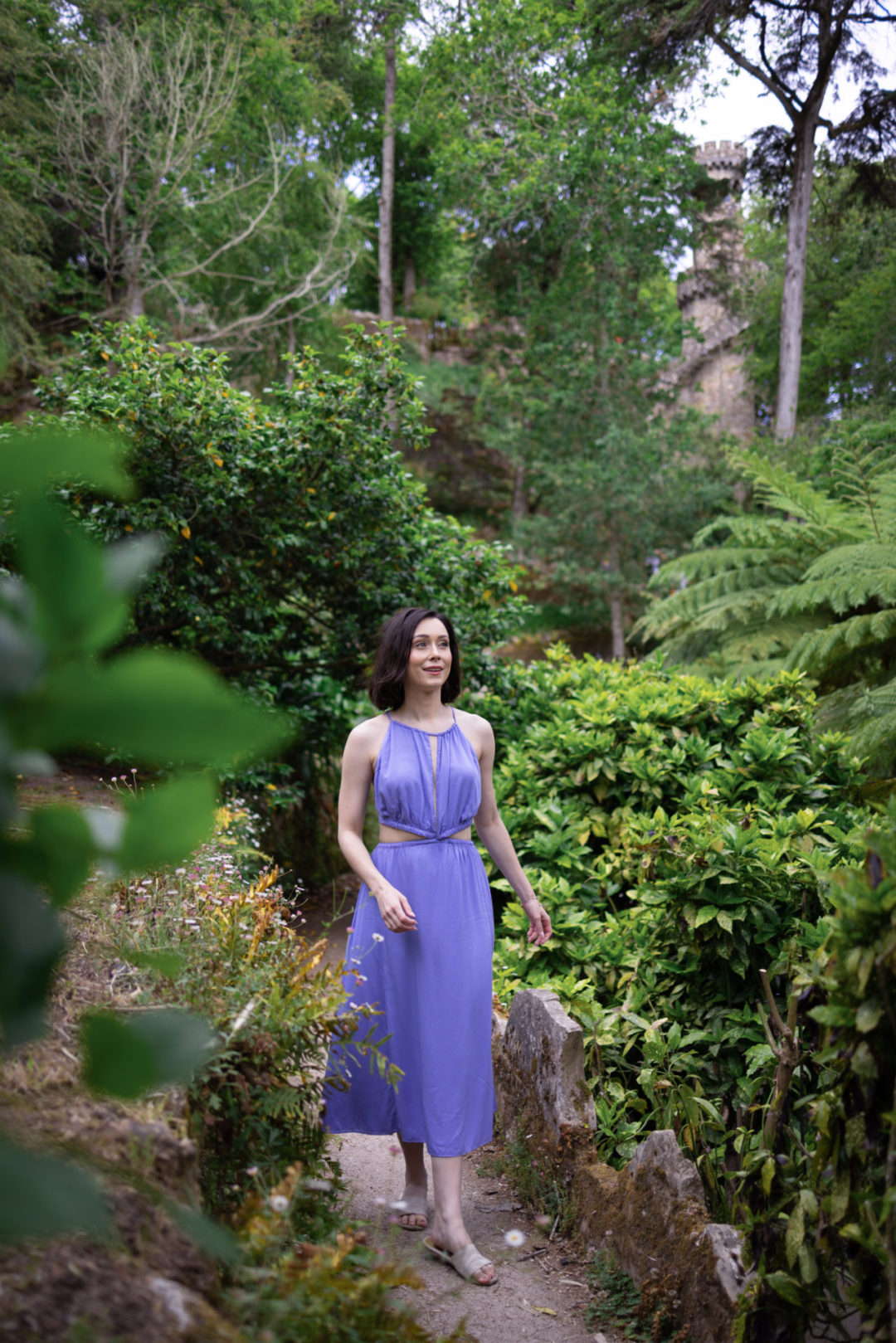Travel Blogger Jordan Gassner wearing a lilac anna nata dress while exploring the gardens at Quinta Da Regaleira in Sintra, Portugal