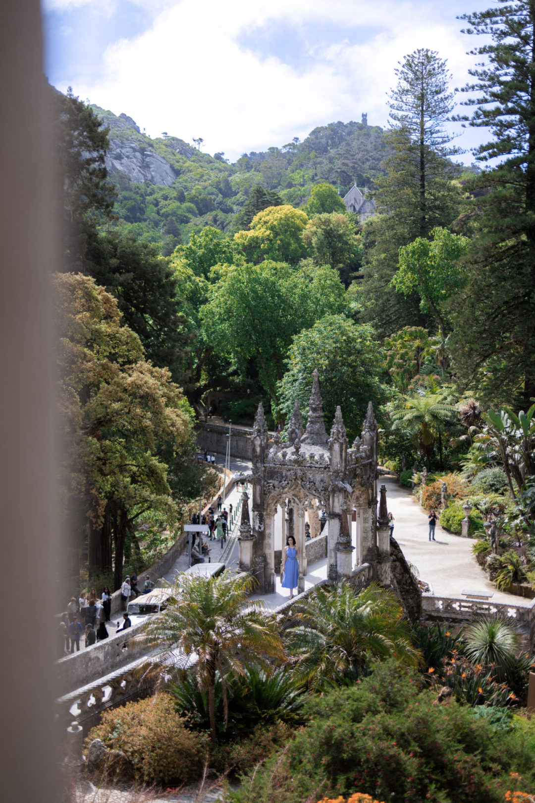 Travel Blogger Jordan Gassner standing under an arch leading from the Quinta Da Regaleira Palace to the Gardens