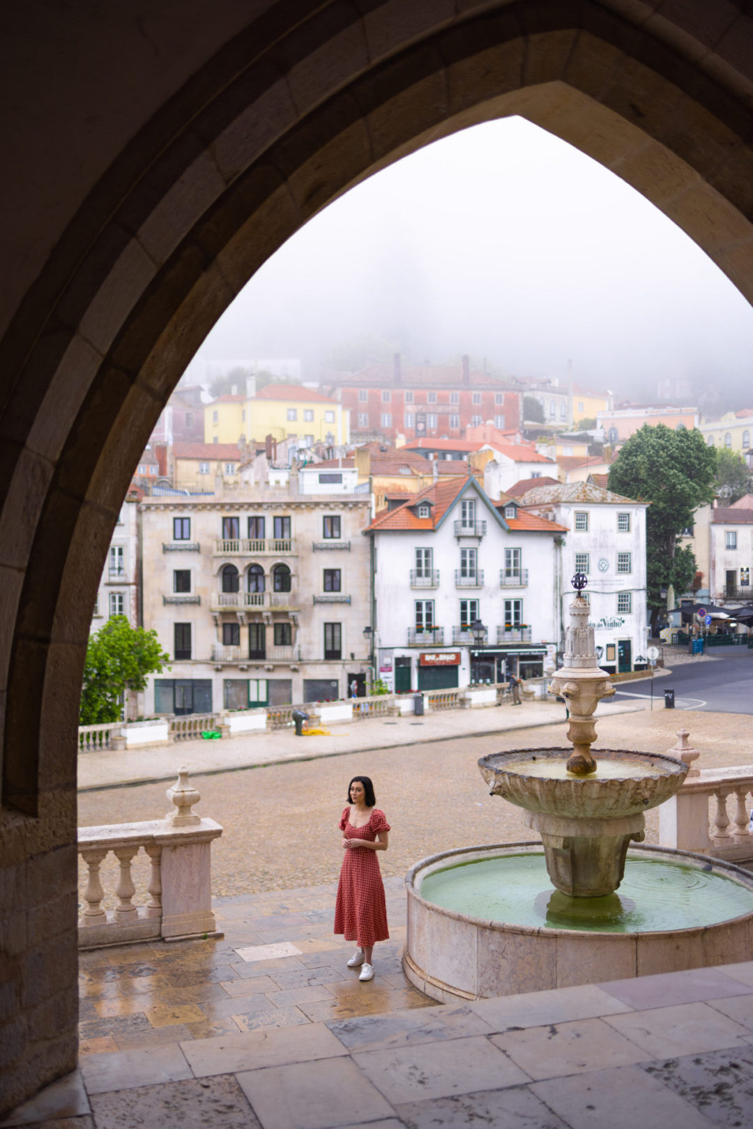 Travel Blogger Jordan Gassner standing next to a fountain in front of an empty square by Sintra national Palace in Portugal