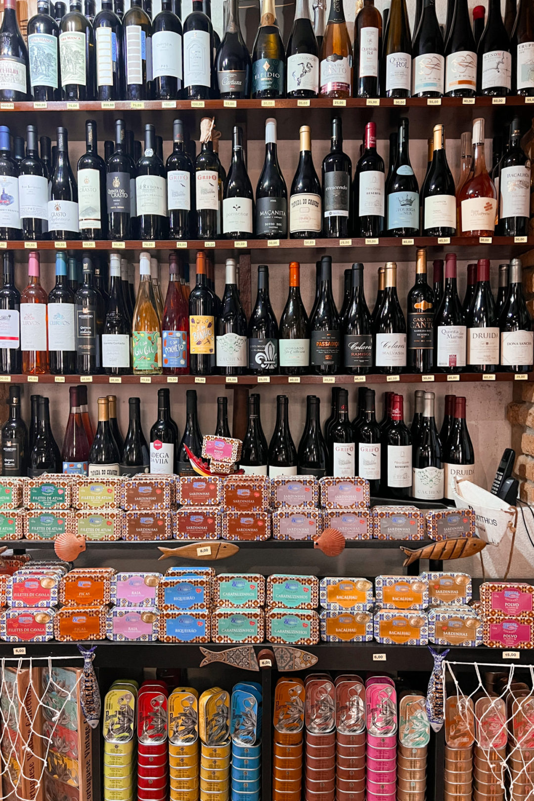 A shelf full of wine and canned fish inside the Cantinho do Lord Byron restaurant in Sintra, Portugal