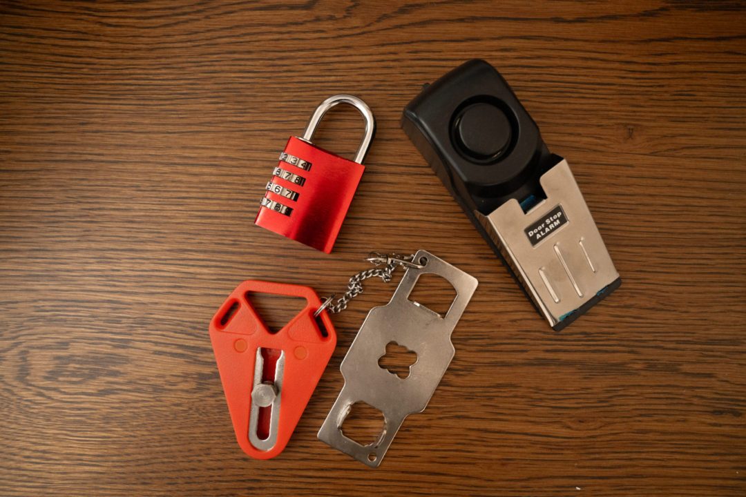 A luggage lock, a door stopper and an external door lock on a wood surface