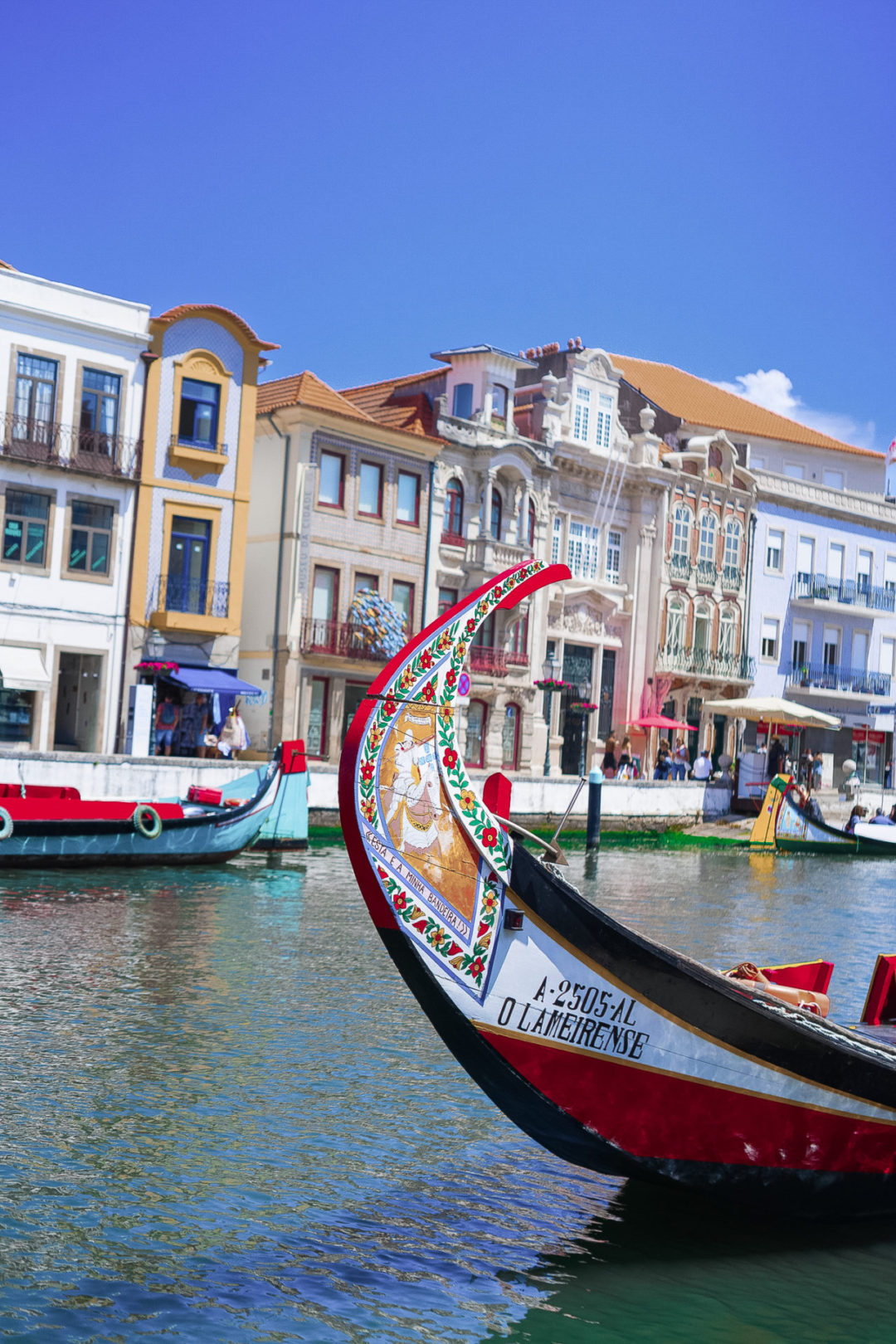 A vibrantly-painted Molceiro boat on a canal in Aveiro, Portugal