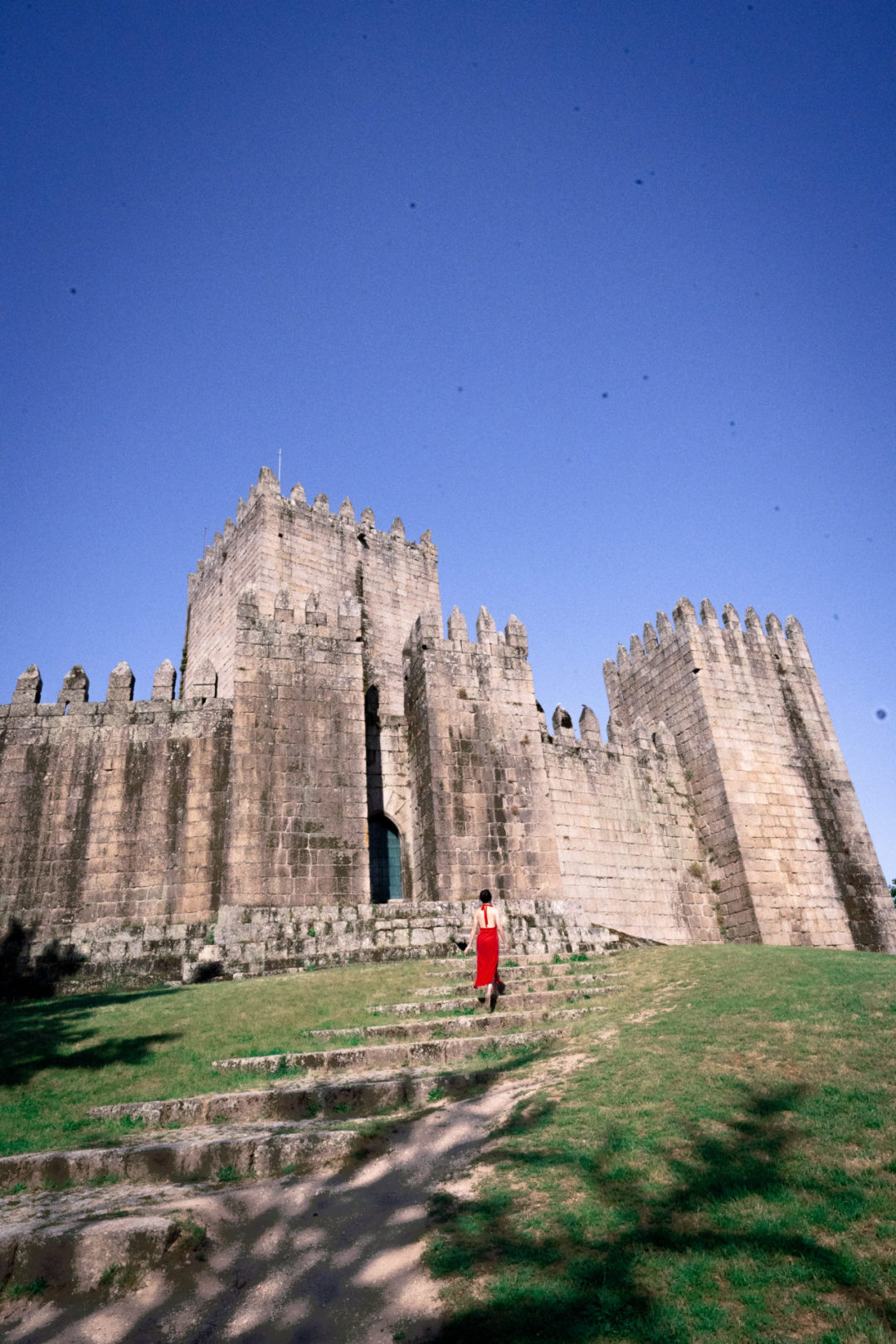 Princess Bride Travel Guide: Travel Blogger Jordan Gassner walking up the steps leading to a gate of Guimaraes Castle in Northern Portugal