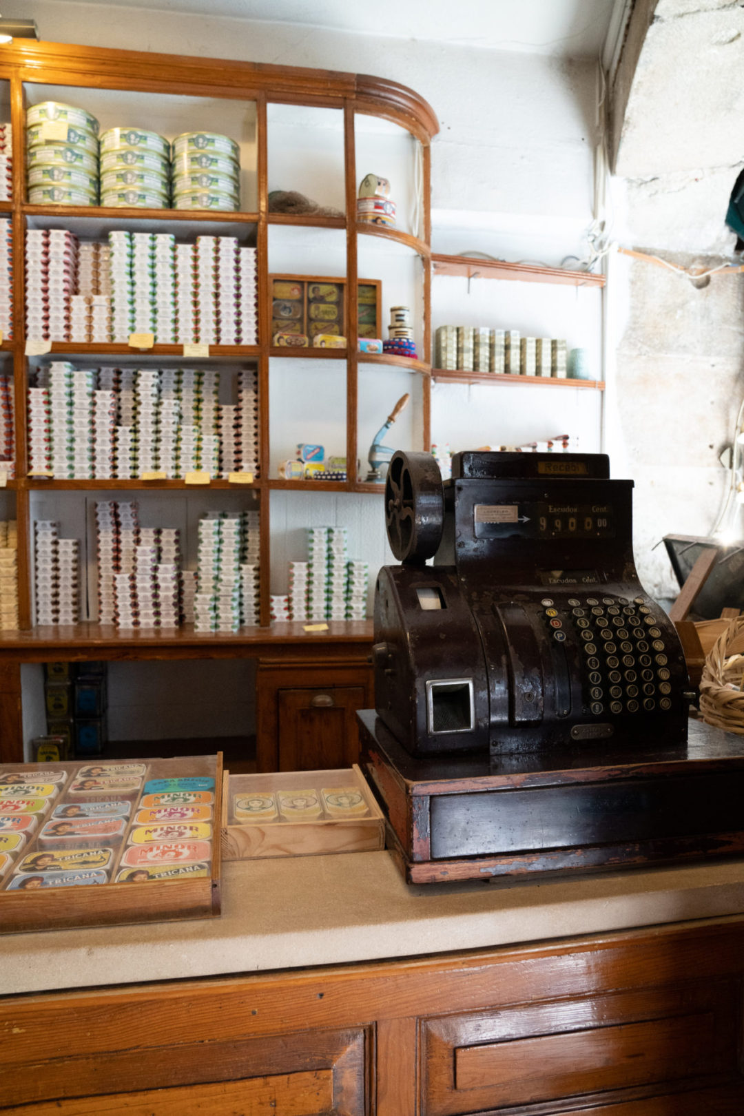 A vintage cash register in front of a wall of conservas, or tinned fish, inside a vintage shop in Lisbon Portugal