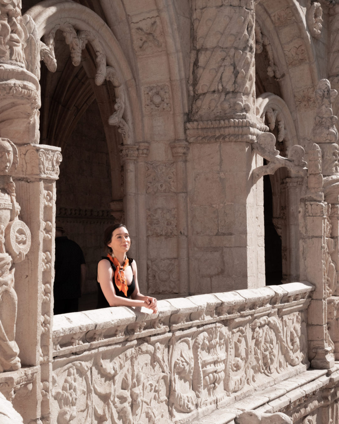 Travel Blogger Jordan Gassner looking out from a balcony inside one of the Jerónimos Monastery Cloisters in Lisbon, Portugal