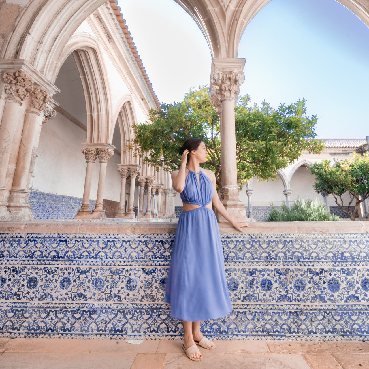 Travel Blogger Jordan Gassner wearing a purple cut out dress in the Convent of Christ in Tomar, Portugal