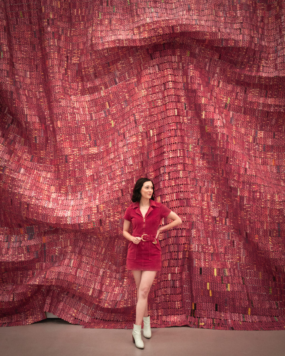 Travel Blogger Jordan Gassner smiling in front of a giant red piece of art inside The Broad in Los Angeles, California