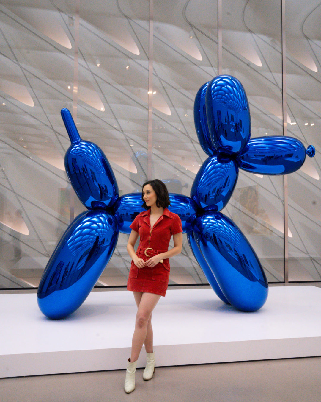 Travel Blogger Jordan Gassner standing next to a sculpture of a giant blue ballon-dog at The Broad in Los Angeles, California