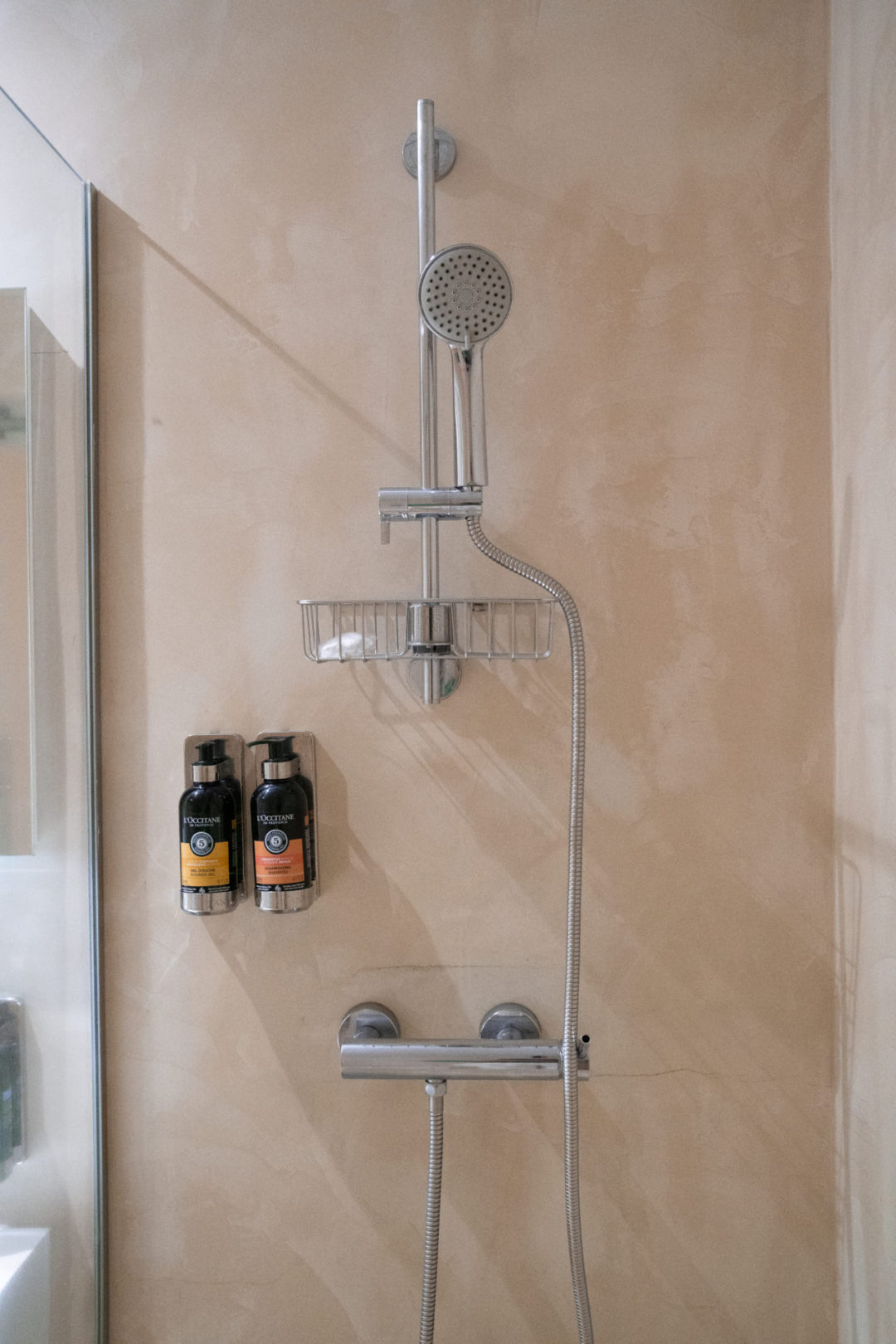 A shower setup with L'Occitane shampoo and conditioner in a room at Lamego Hotel and Life in Portugal
