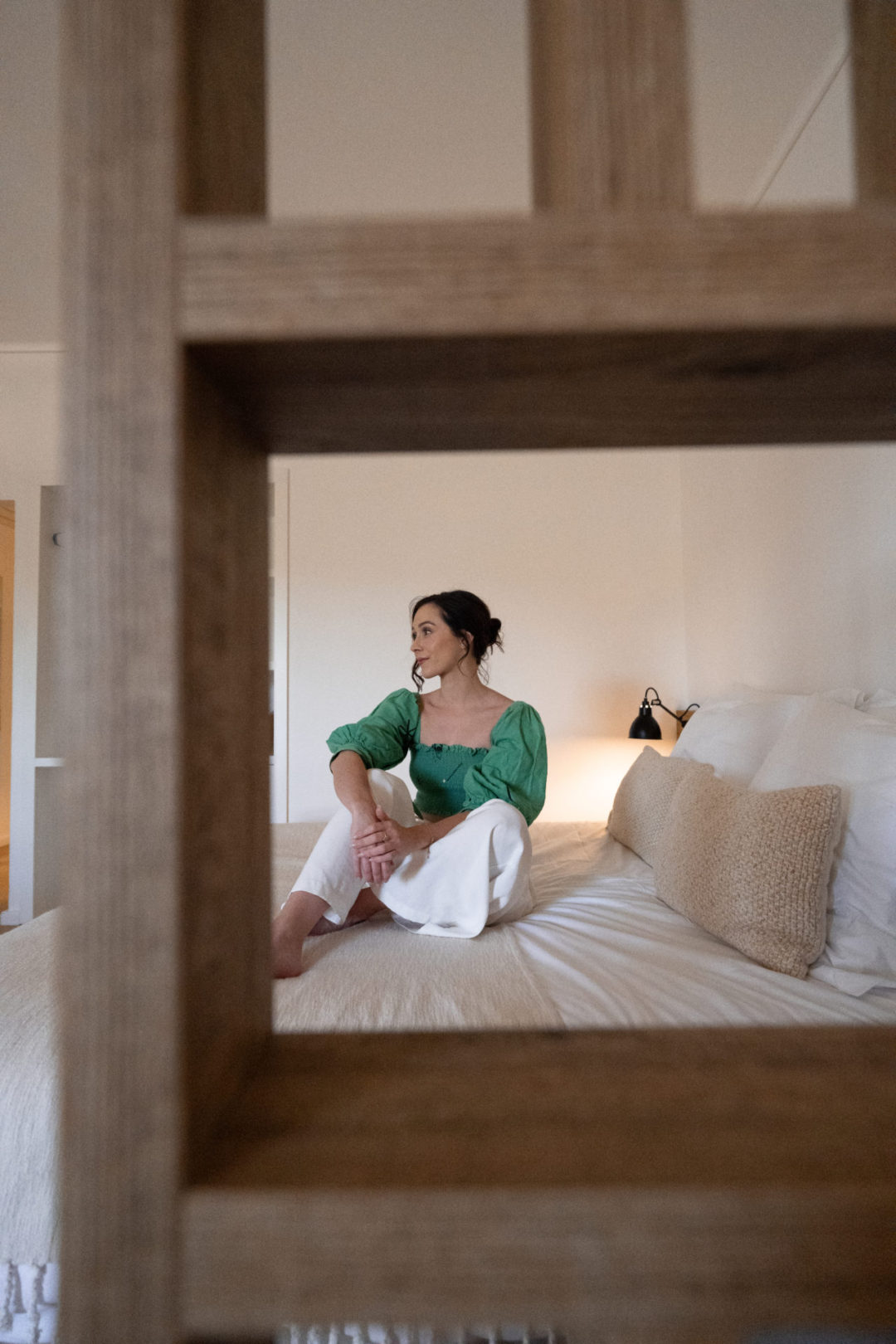 Travel Blogger Jordan Gassner sitting on a bed while watching TV inside a room at Lamego Hotel & Life in Portugal's Douro Valley