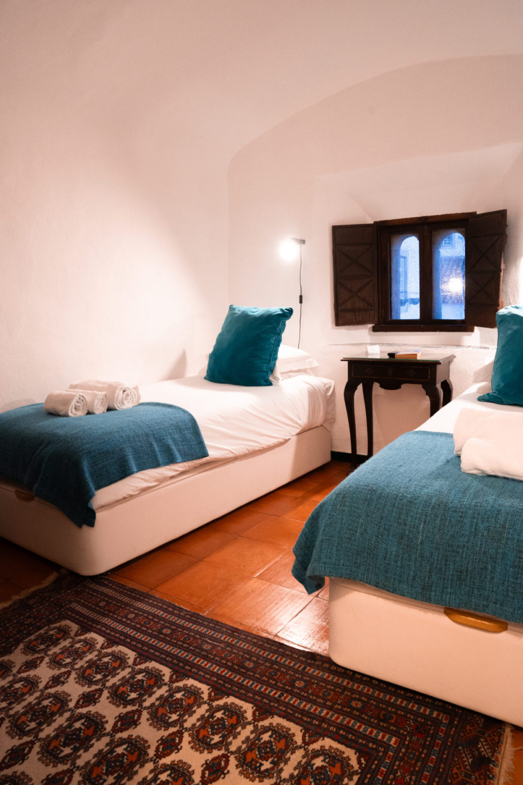 Two twin beds inside a room of Torre De Maneys, a medieval style hotel in Obidos, Portugal
