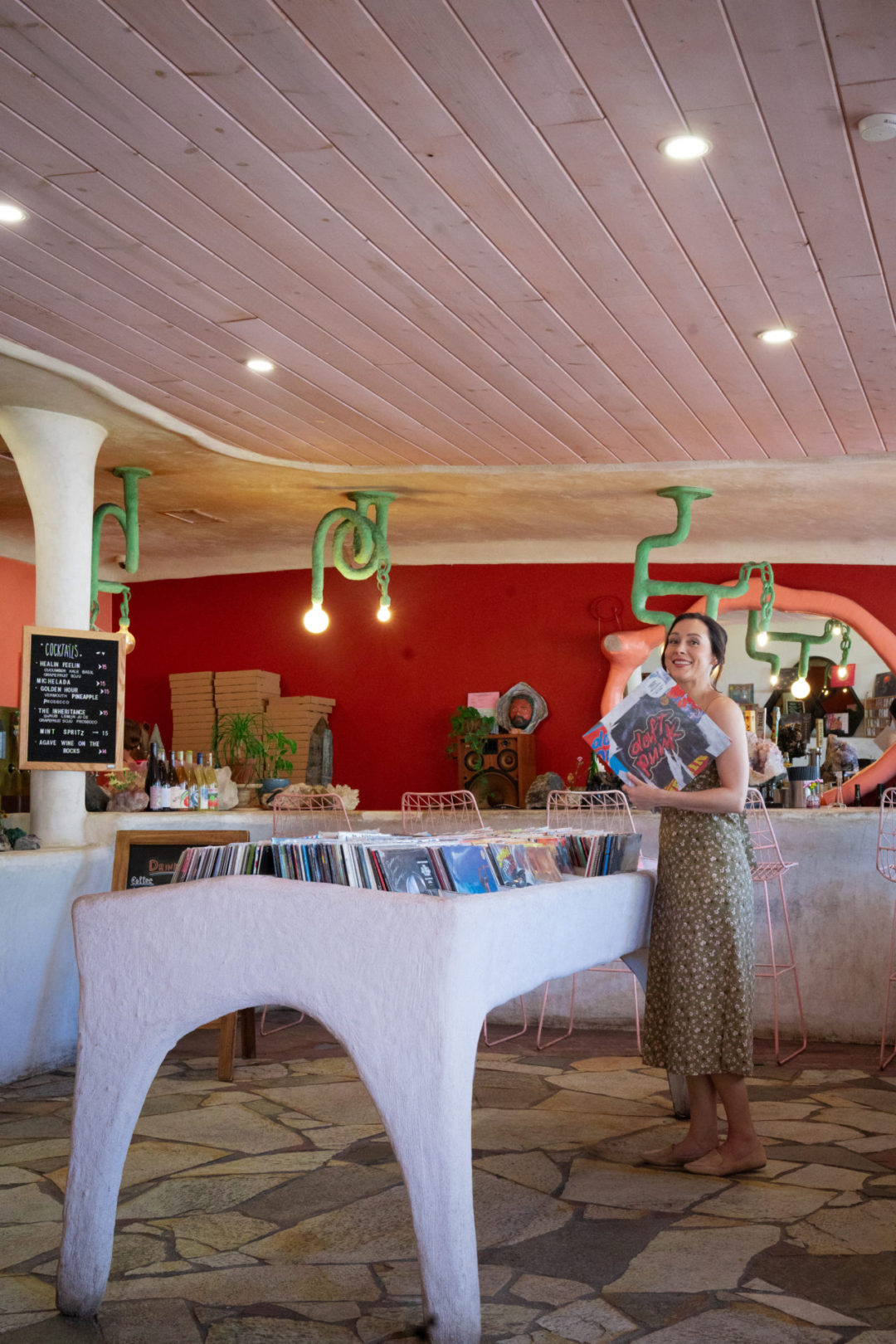 Travel Blogger Jordan Gassner smiling with a Daft Punk record inside Endless Color natural wine shop in Los Angeles