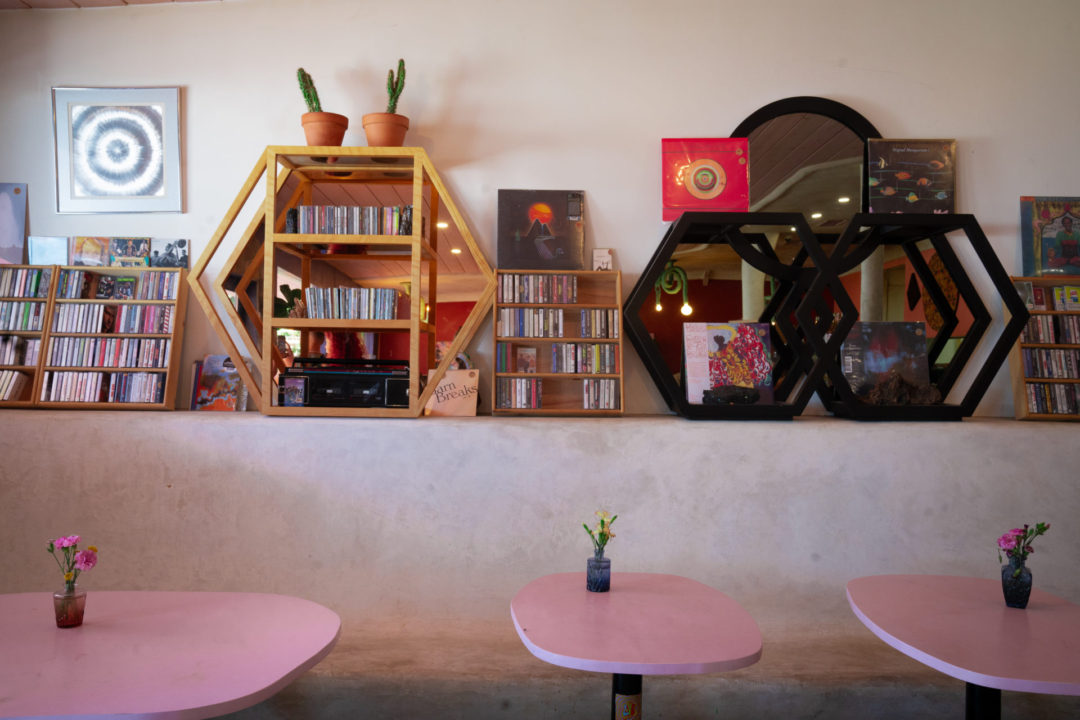 A pink set of tables and a cassette tape collection inside Endless Color natural wine shop in Topanga Canyon, California