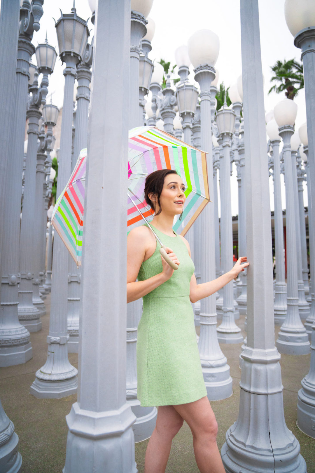 Travel Blogger Jordan Gassner walking through the "Urban Light" installation outside of LACMA during a rare rainy LA day