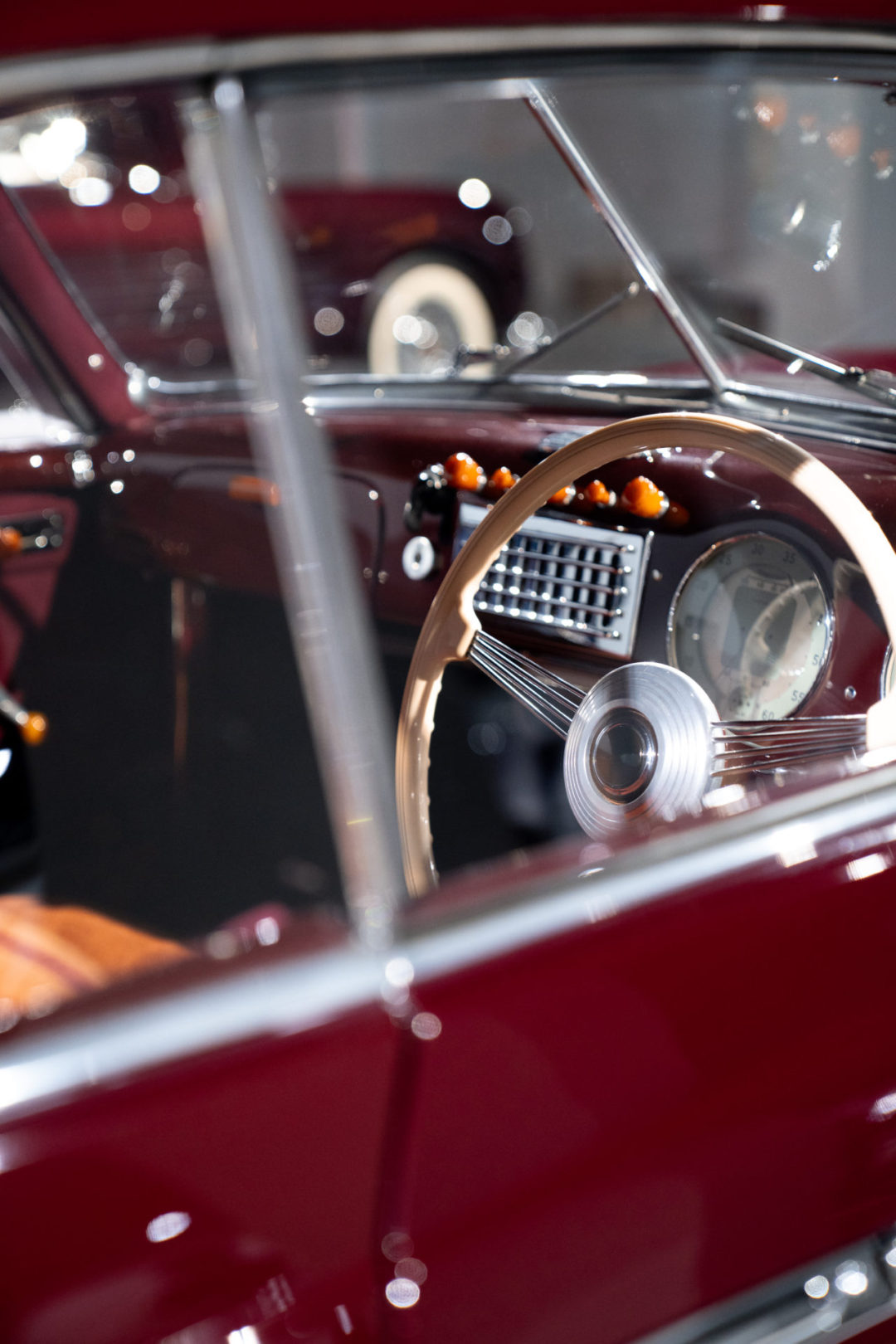 The interior of a burgundy 1947 Cisitalia 202 Coupe inside the Petersen Automotive Museum in Los Angeles, California