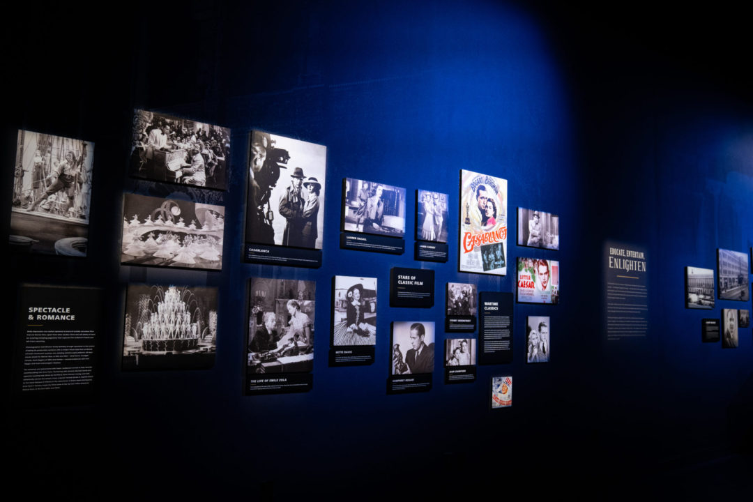 A group of classic movie photos along a timeline in the Storytelling Showcase room in the Warner Bros. Studio Tour