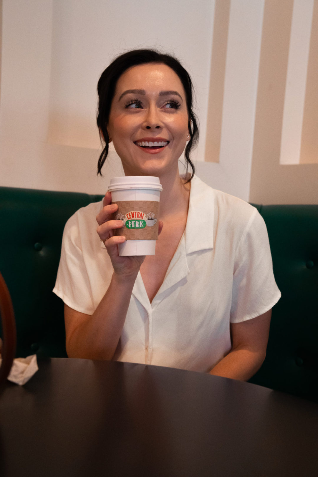 Travel Blogger Jordan Gassner drinking. acup of tea with a sleeve that reads "Central Perk"