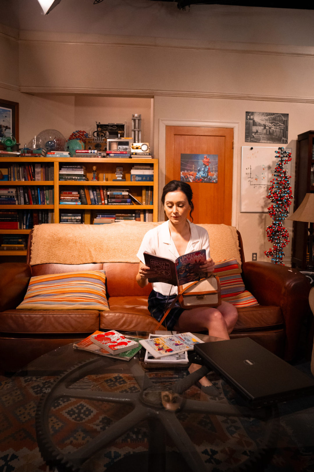 Travel Blogger Jordan Gassner sitting and pretending to read a comic book in a Big Bang Theory inspired photo-op on the Warner Bros. Studio Tour