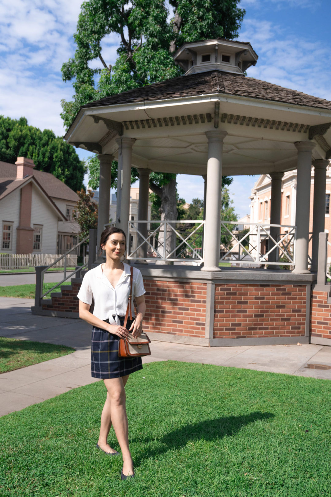 Travel Blogger Jordan Gassner smiling in front of the Gilmore Girls gazebo in the Warner Bros. Studio backlot