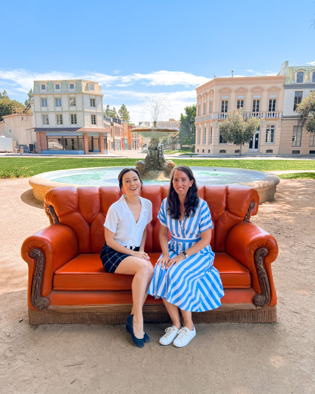 Travel Blogger Jordan Gassner and her friend Kate sitting in front of the iconic Friends fountain on the Warner Bros. Studio Backlot