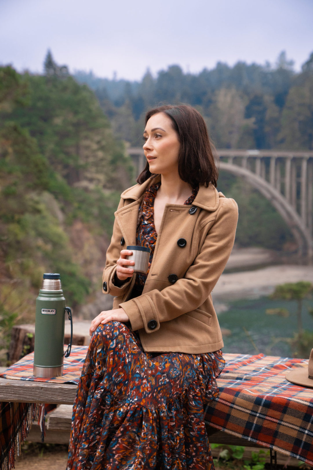 Travel Blogger Jordan Gassner sitting on a bench overlooking the Russian Gulch State Park Bridge near the Mendocino Coast in California, USA