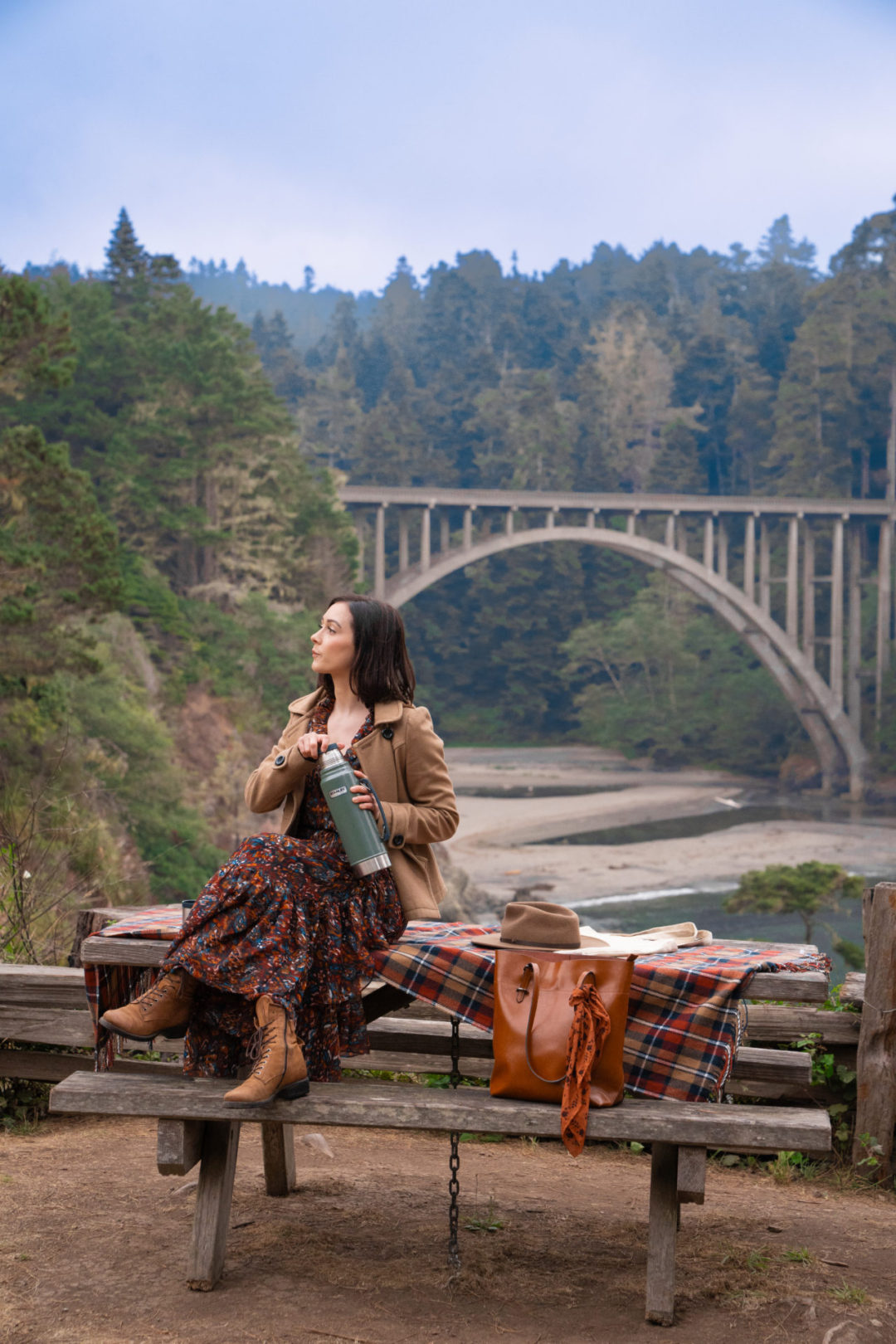 Travel Blogger Jordan Gassner screwing a lid on a thermos the Russian Gulch State Park Bridge near the Mendocino Coast in California