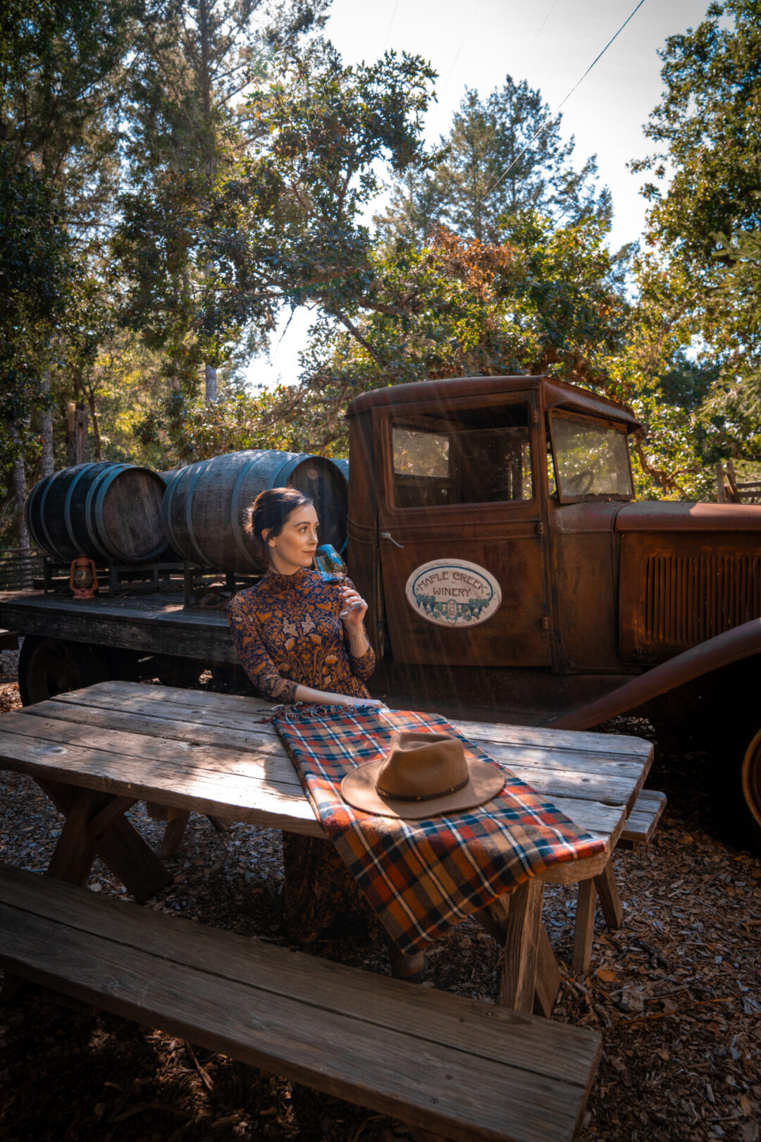 Travel Blogger Jordan Gassner smelling a glass of wine while seated at a picnic table at Maple Creek Winery in California's Mendocino County