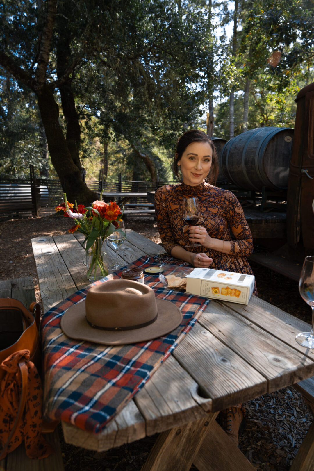 Travel Blogger Jordan Gassner smiling from a picnic table at Maple Creek Winery in California's Mendocino County